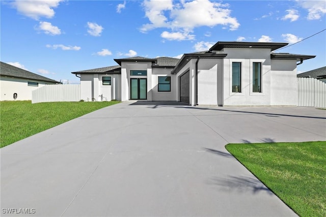 prairie-style home with a garage and a front lawn