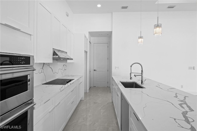 kitchen with light stone counters, black electric cooktop, extractor fan, sink, and white cabinets