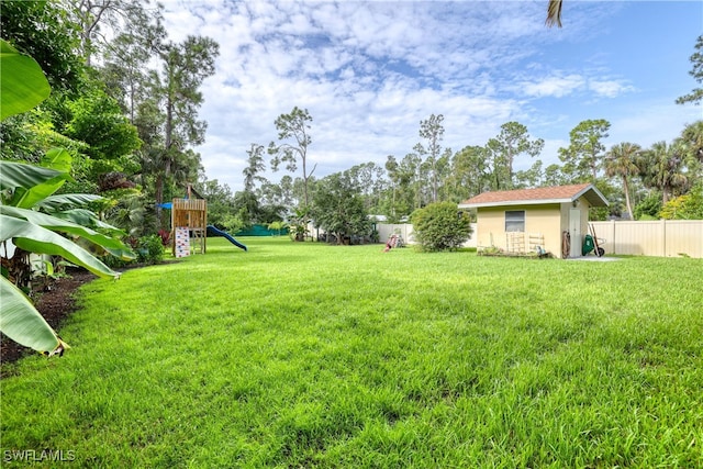 view of yard featuring a playground and an outbuilding