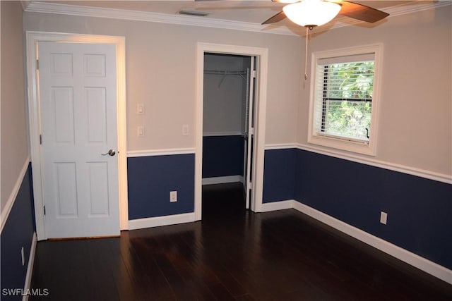 unfurnished bedroom featuring a closet, ceiling fan, crown molding, and dark hardwood / wood-style floors