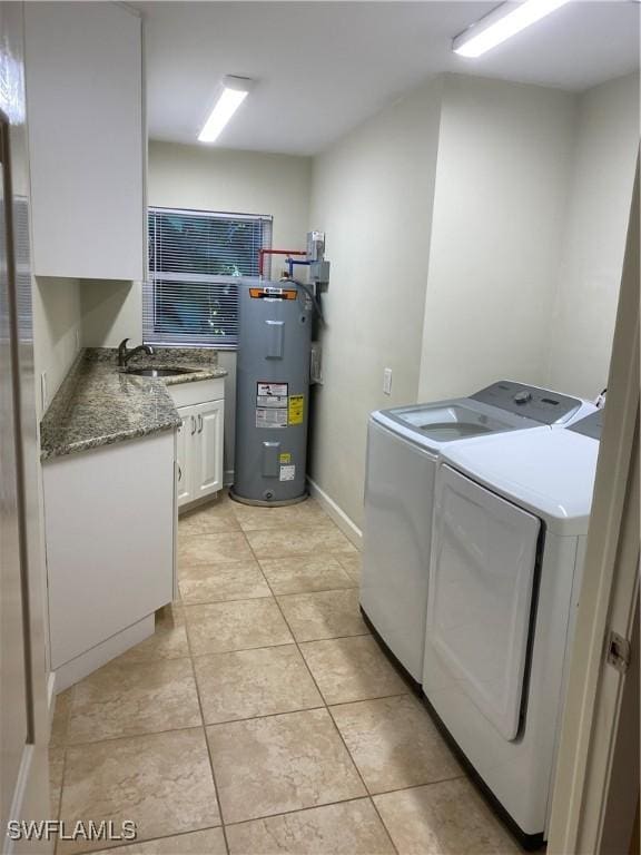 clothes washing area with cabinets, water heater, sink, washer and clothes dryer, and light tile patterned flooring