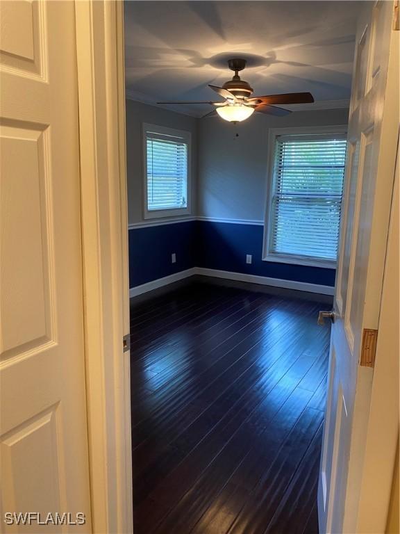 unfurnished room featuring ceiling fan and dark hardwood / wood-style flooring