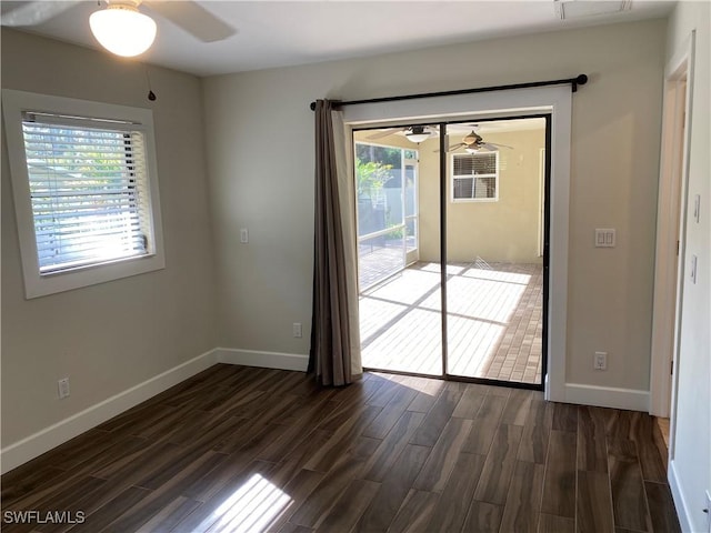 unfurnished room featuring ceiling fan, a wealth of natural light, and dark hardwood / wood-style floors