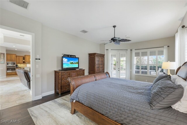 bedroom featuring wood-type flooring, french doors, access to outside, and ceiling fan