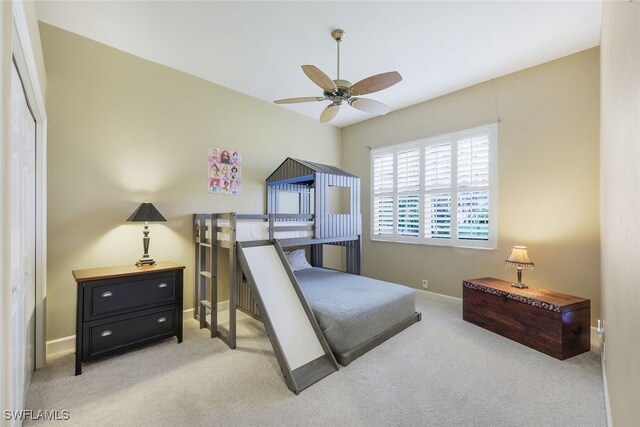 carpeted bedroom with ceiling fan and a closet