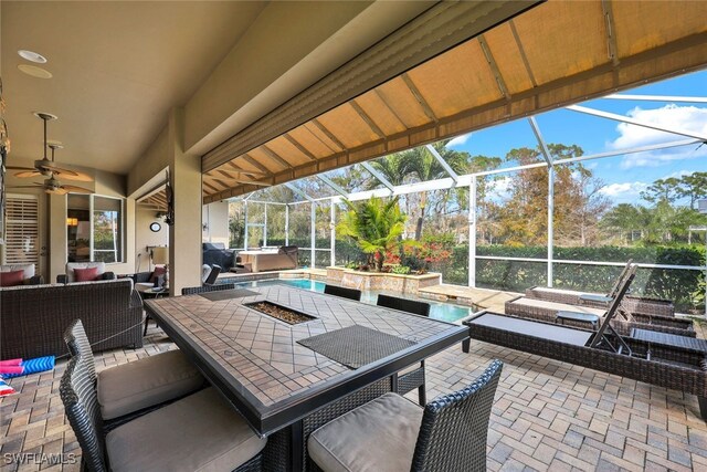 view of patio / terrace with outdoor lounge area, a pool with hot tub, ceiling fan, and glass enclosure