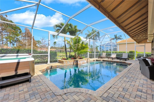 view of swimming pool featuring glass enclosure, a hot tub, and a patio area