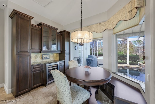 dining space featuring wine cooler and a chandelier