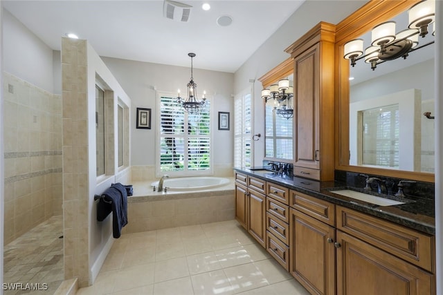 bathroom featuring plus walk in shower, vanity, tile patterned floors, and a notable chandelier