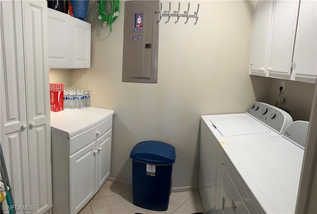 laundry room with electric panel, cabinets, washer and clothes dryer, and light tile patterned floors