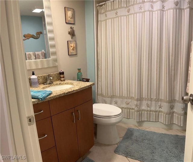 bathroom featuring toilet, curtained shower, tile patterned floors, and vanity