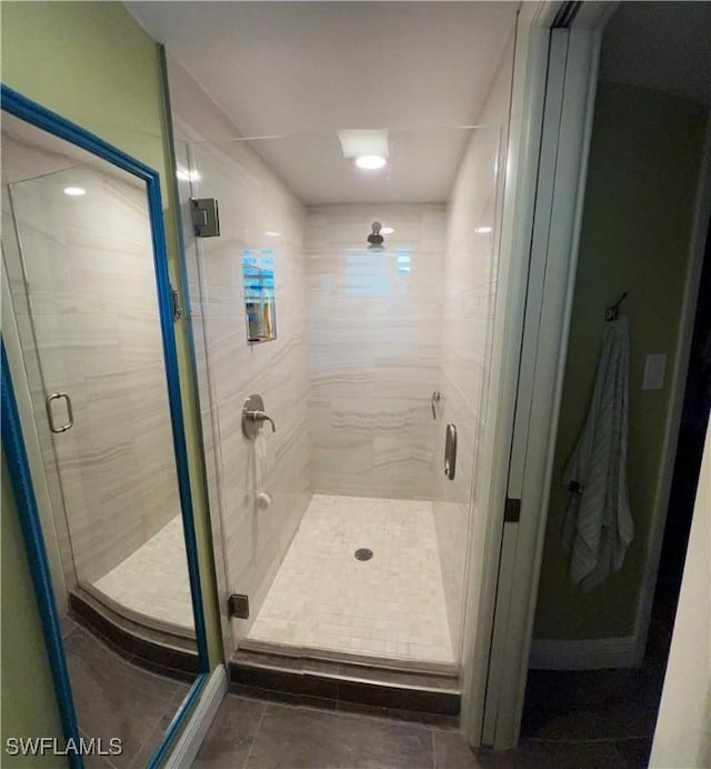 bathroom featuring tile patterned flooring and a shower with shower door