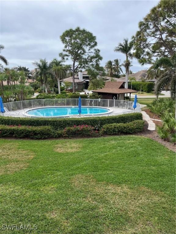 view of swimming pool with a yard