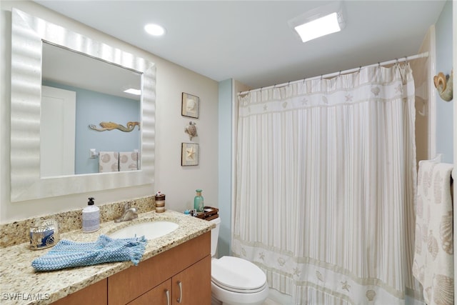 bathroom featuring vanity, curtained shower, and toilet