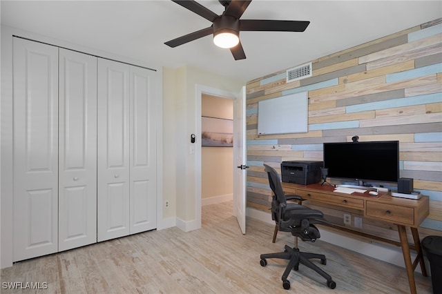 office space with light hardwood / wood-style flooring, ceiling fan, and wood walls