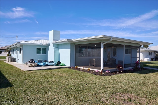 rear view of property with a sunroom and a lawn