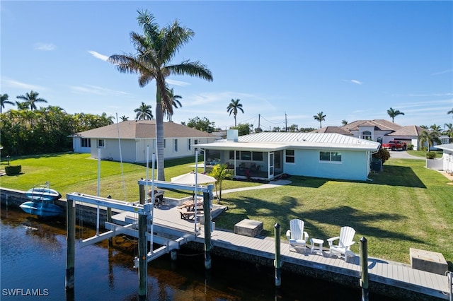 dock area with a water view and a lawn