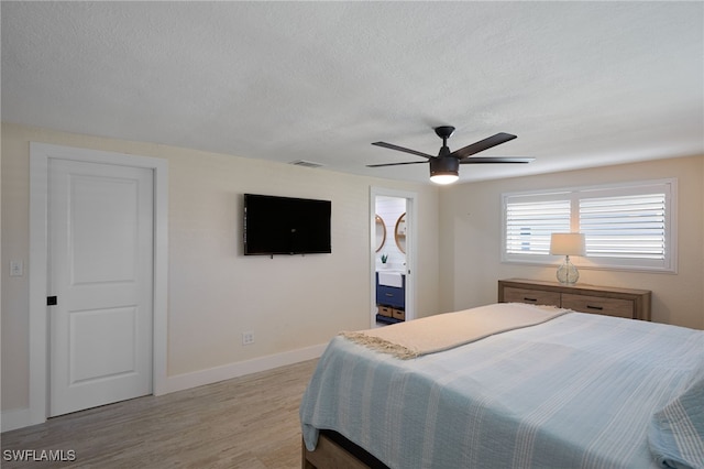 bedroom featuring a textured ceiling, light hardwood / wood-style flooring, and ceiling fan