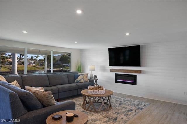 living room with light wood-type flooring and wood walls