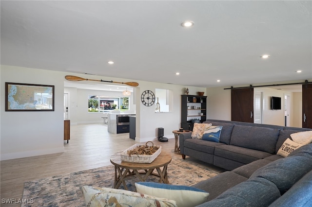 living room featuring light hardwood / wood-style flooring and a barn door