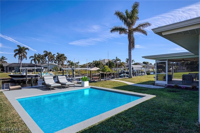 view of swimming pool featuring a water view, a boat dock, and a lawn