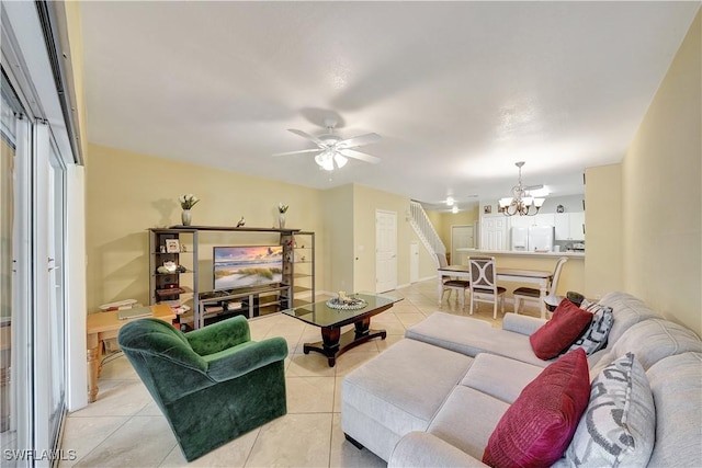 living room with light tile patterned floors and ceiling fan with notable chandelier