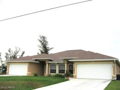 single story home with a front yard and a garage