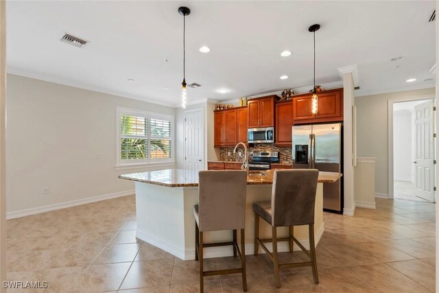 kitchen with appliances with stainless steel finishes, ornamental molding, pendant lighting, a center island with sink, and light tile patterned flooring