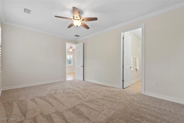 spare room with ceiling fan, ornamental molding, and light carpet