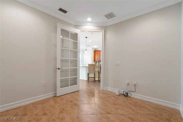 empty room featuring crown molding and light tile patterned floors