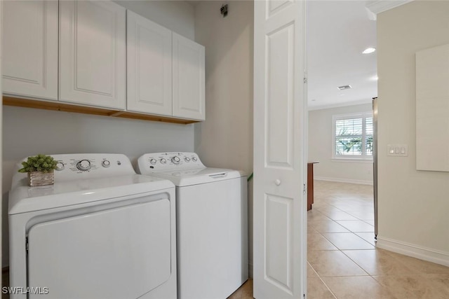 laundry area with crown molding, light tile patterned floors, cabinets, and independent washer and dryer