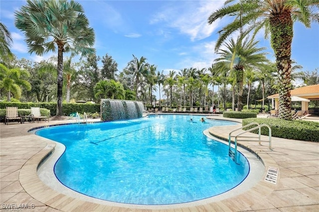 view of swimming pool featuring pool water feature and a patio