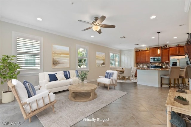 tiled living room with ceiling fan, ornamental molding, and sink