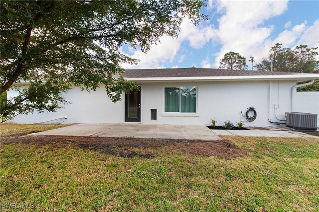 rear view of property with a yard, central AC, and a patio area