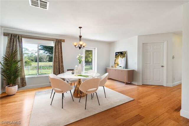 dining area featuring a chandelier and light hardwood / wood-style flooring