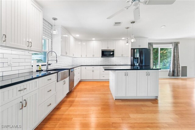 kitchen with white cabinetry, decorative light fixtures, and appliances with stainless steel finishes