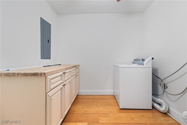 washroom with cabinets, light wood-type flooring, electric panel, and washer / clothes dryer