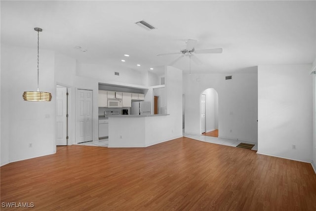 unfurnished living room with ceiling fan, light hardwood / wood-style floors, and lofted ceiling