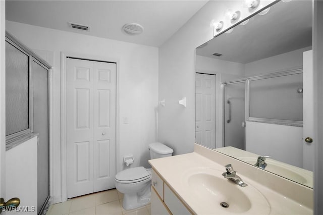 bathroom featuring tile patterned floors, vanity, a shower with shower door, and toilet