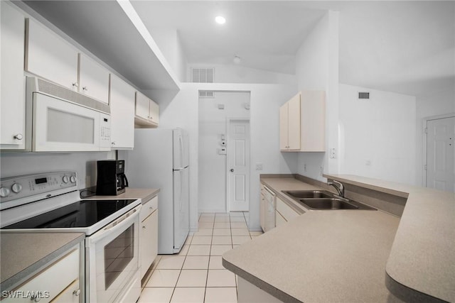 kitchen featuring lofted ceiling, sink, light tile patterned floors, and white appliances