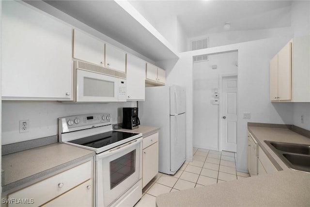 kitchen featuring lofted ceiling, white appliances, sink, and light tile patterned floors