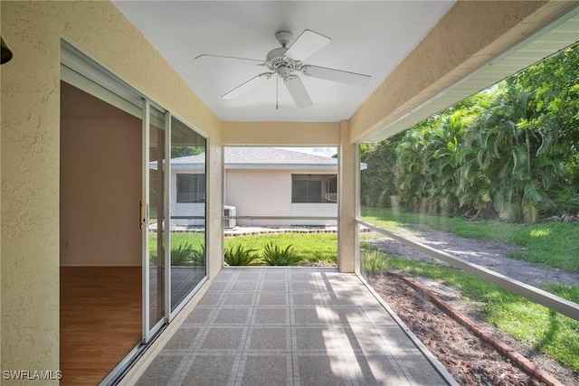 unfurnished sunroom with ceiling fan