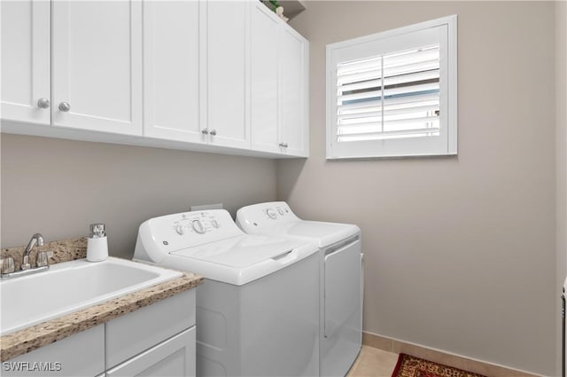 laundry room with cabinets, separate washer and dryer, light tile patterned floors, and sink