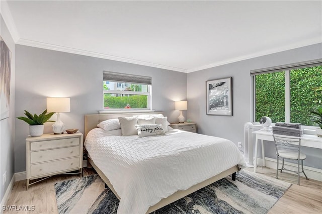 bedroom featuring multiple windows, crown molding, and light hardwood / wood-style floors