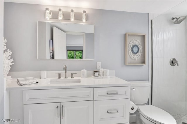 bathroom featuring vanity, toilet, and a tile shower