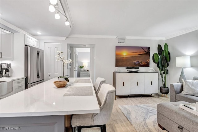 dining area with crown molding and light hardwood / wood-style flooring