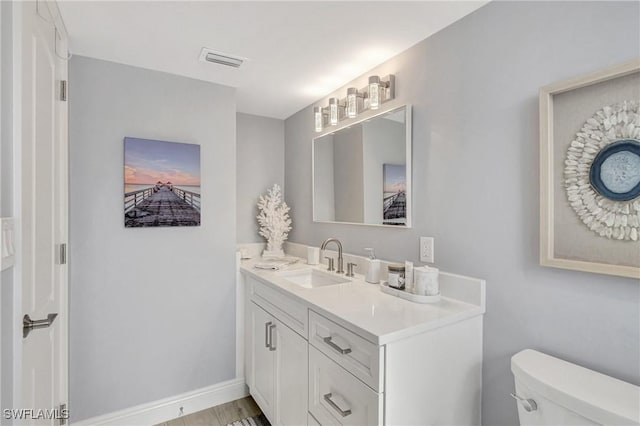 bathroom featuring vanity, toilet, and hardwood / wood-style floors