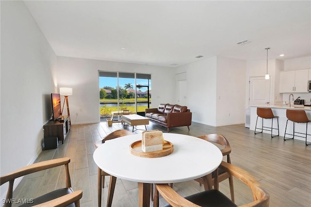 dining space featuring sink and light wood-type flooring