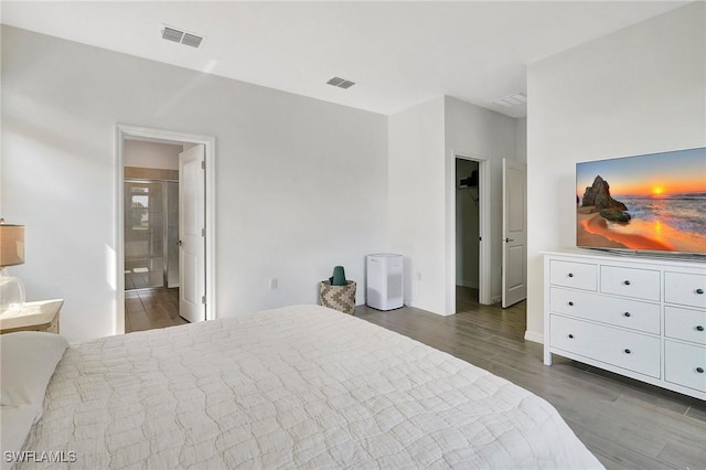 bedroom featuring dark hardwood / wood-style flooring and ensuite bathroom