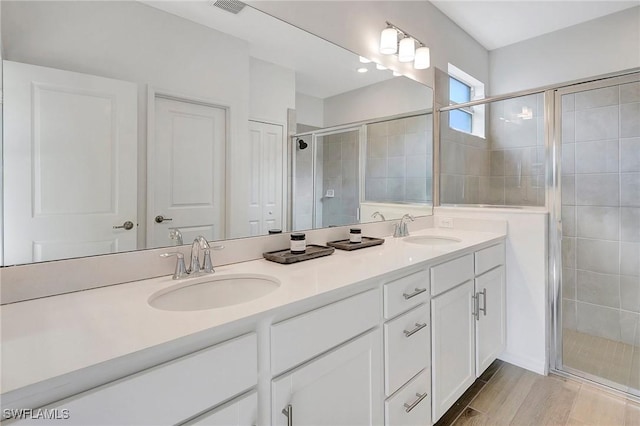 bathroom with vanity, an enclosed shower, and wood-type flooring